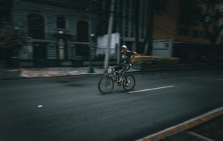 Freihändig Radfahren und andere Verbote: Was die StVO für Radfahrer regelt 6 A cyclist rides down a dark city street.