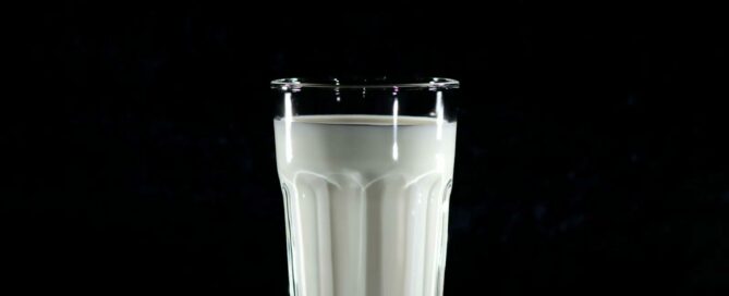Jeden Tag Milch trinken: Wie gesund ist das wirklich 2 A glass of fresh milk against a black background, emphasizing simplicity and nutrition.